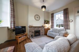 a living room with a couch and a fireplace at Dales View Cottage in Sedbergh