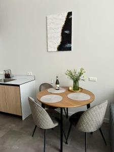 een keuken met een houten tafel met stoelen en een wastafel bij Albatross Loft in Ķesterciems