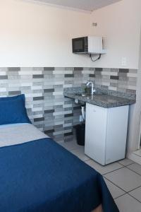 カボ・フリオにあるReduto Praiano - Thaiz Hospedagemのベッドルーム1室(ベッド1台、シンク、電子レンジ付)