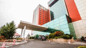 a car parked in front of a tall building at Sudului ApartHotel in Bucharest