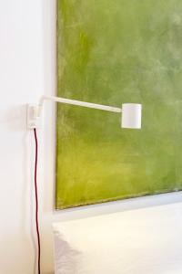 a white light next to a green painting at Hotel Tafelfreuden in Oldenburg