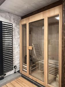 a room with glass doors and a stone wall at WELLNESS Chalet OXY in Ždiar