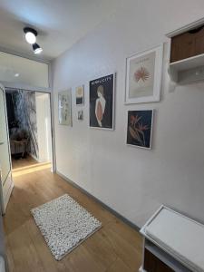 a room with a white wall with pictures and a rug at Cozy Boutique Apartment in Plovdiv in Plovdiv