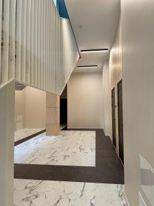um corredor com piso em mármore e uma escada em Albatross Loft em Ķesterciems