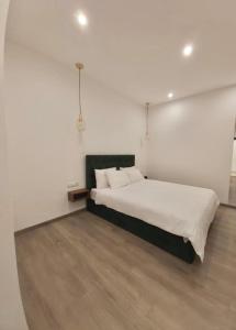 a bedroom with a bed with white walls and wooden floors at Real City Suites Syntagma in Athens