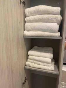 a group of towels on a shelf in a bathroom at Apartment near Como and Milan with private garage in Mozzate