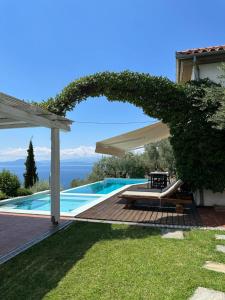 a pool with a wooden deck and a pergola at Elia Pilio Villas in Pilion