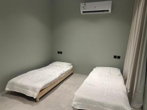 2 aparte bedden in een kamer met airconditioning bij مزرعة الخير 