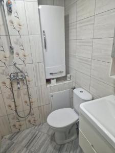 a bathroom with a white toilet and a sink at Къща в центъра in Dobrich