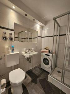 een badkamer met een toilet en een wasmachine bij 2-Zimmer, Balkon, Parkplatz in Mülheim an der Ruhr