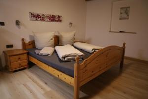 a bedroom with a wooden bed with two pillows on it at Ferienwohnung Kindl Manuela in Neustift im Stubaital