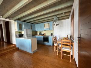cocina con armarios azules, mesa y sillas en Elia Pilio Villas, en Pelión