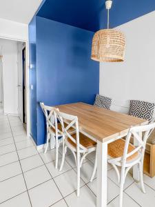 comedor con paredes azules y mesa y sillas de madera en Azure Escape, en Saint-Raphaël