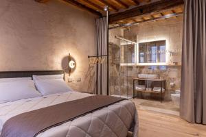 een slaapkamer met een groot bed en een badkamer bij Truffle House Tuscany Tuber Melanosporum Vitt in Montepulciano