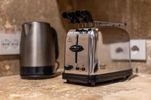a toaster sitting on a counter next to a cup at Truffle House Tuscany Tuber Melanosporum Vitt in Montepulciano