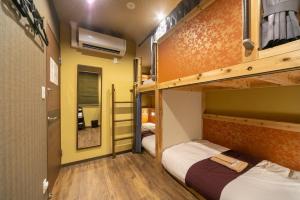 two bunk beds in a room with yellow walls and wooden floors at IKIDANE Cozy Hotel Haneda Airport - Vacation STAY 25834v in Tokyo