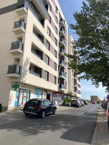 a black car parked in front of a building at Happy apartment 1 in Roşu