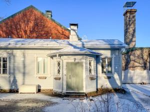 an old white house with a green door at Villa Primavera Apartment in Hanko in Hanko