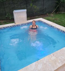 a young girl is swimming in a swimming pool at Villa Diosa in Jarabacoa