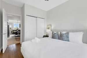 a white bedroom with a large bed and a living room at Lofts de la petite Italie in Montréal
