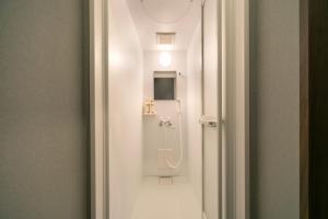 bagno con doccia in una camera bianca di IKIDANE Cozy Hotel Haneda Airport - Vacation STAY 25843v a Tokyo
