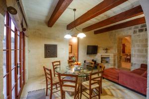 a living room with a table and chairs and a couch at 5 Bedroom Farmhouse with Private Pool & Views in Għarb