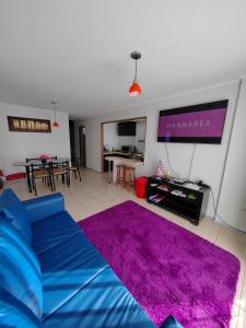 ein Wohnzimmer mit einem blauen Sofa und einem lila Teppich in der Unterkunft Arriendo Diario En La Serena in La Serena