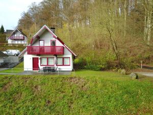 ein rotes und weißes Haus auf einem Hof in der Unterkunft Huis 38 Seepark Kirchheim in Kirchheim