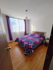 1 dormitorio con 1 cama con un edredón colorido en Arriendo Diario En La Serena en La Serena