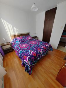 1 dormitorio con 1 cama con una manta colorida en Arriendo Diario En La Serena en La Serena