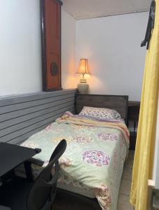 a bedroom with a bed and a table and a lamp at moon lotus abode(月蓮居) in New York