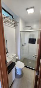 a bathroom with a toilet and a glass shower at Maracabeach2 / 201 in Porto De Galinhas