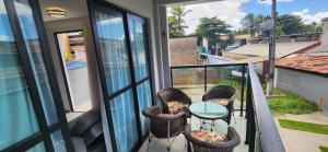 a balcony with chairs and a glass table at Maracabeach2 / 201 in Porto De Galinhas