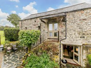 an old stone house with a balcony in a garden at 1 Bed in Tavistock HIGHM in Marytavy