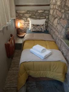a bedroom with a bed with towels on it at Αυθεντικό πετρινο στην Ναύπακτο in Nafpaktos