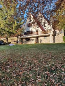 a house in a yard with leaves on the grass at Chalet Edelweiss Marsia-Tagliacozzo 1500mt in Marsia