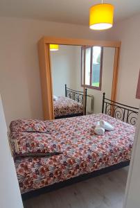 1 dormitorio con cama y espejo en Charming house near the sea, en Courseulles-sur-Mer