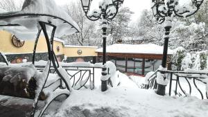 un banco cubierto de nieve en un patio en Маришки дол, en Raduil