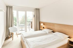 um quarto de hotel com duas camas e uma varanda em APPADU Appartements em St. Gallen