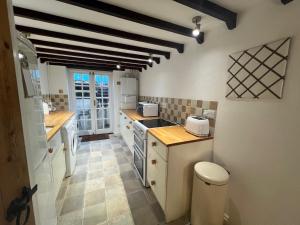 a kitchen with a sink and a stove at Angel Cottage in Bishopsteignton