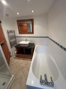 een badkamer met een ligbad en een wastafel bij Angel Cottage in Bishopsteignton +51 foto's