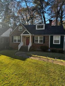 a house with a red door on a yard at Modern 3BD Cottage Home w/Private HotTub in Atlanta