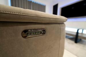 a close up of a brown couch with a remote control at Luxury, Modern & Cosy 1 Bedroom Prestige London Apartment in London