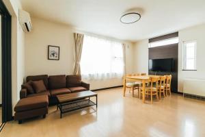 旭川的住宿－STAY IN ASAHIBASHI - Vacation STAY 26632v，客厅配有沙发和桌子