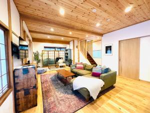 uma sala de estar com um sofá e uma mesa em Hakuba Bliss Cottage - Vacation STAY 28524v em Hakuba