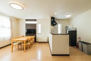a kitchen and dining room with a table and a refrigerator at STAY IN ASAHIBASHI - Vacation STAY 26632v in Asahikawa