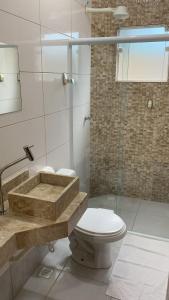 uma casa de banho com um WC, um lavatório e um chuveiro em Pousada Recanto Som do Mar em Caraguatatuba