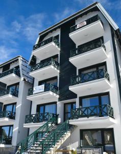 an apartment building with balconies and stairs at Hiona Apartment in Kopaonik