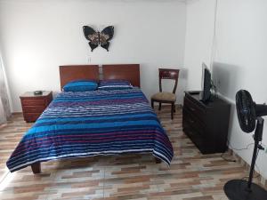 1 dormitorio con 1 cama con una mariposa en la pared en Casa de renta vacacional Andy-Cali -Valle del Cauca en Cali
