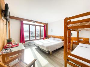 a bedroom with two bunk beds and a desk at Atmosphere Hotel in Les Deux Alpes